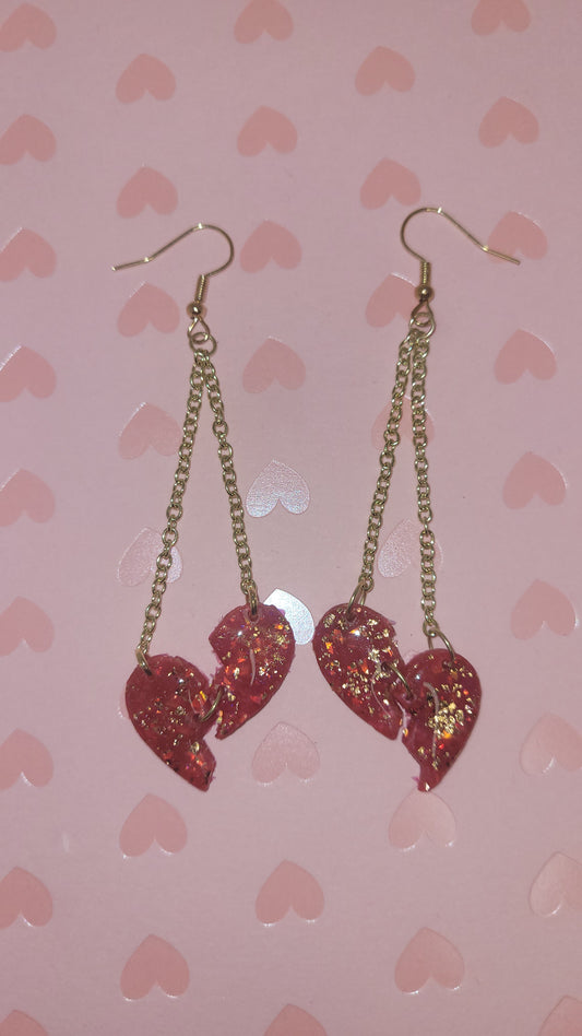 heartbreak dangles laid on a pink heart background (with flash)