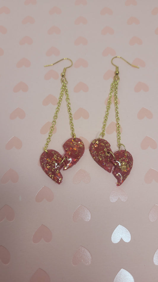 heartbreak dangles laid on a pink heart background (without flash)